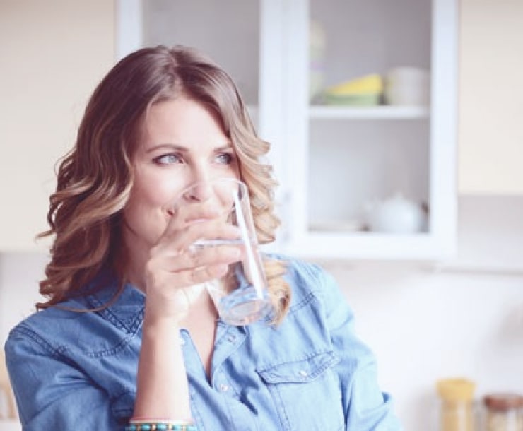 woman drinking water out of a bottleless drinking water system